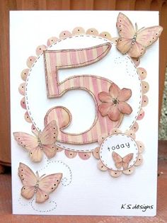 a birthday card with pink butterflies and the number five in it's center, on top of a wooden table