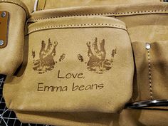 a pair of brown leather gloves with love emana beans written on the side and hand prints