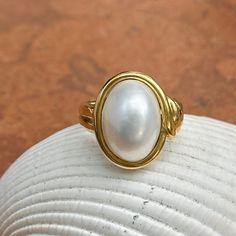 New, but old pieces, never worn, recently acquired from a premier jeweler located in Minneapolis, MN for many years- a rare opportunity! 18KT yellow Ggld genuine, bezel-set, white, oval, mabe pearl ring. Size 6.75 Sizable by us for a fee or your local jeweler Weight: 10.3 grams Band width: 3mm in back Pearl measures: 15mm x 11mm oval mabe pearl Stamped 18k By Honora Timeless Oval Rings With High Luster, Heirloom High Luster Oval Pearl Ring, Classic Cabochon Pearl Ring For Formal Occasions, Classic Formal Pearl Ring With Cabochon, Luxury High Luster Oval Pearl Ring, Luxury Oval Pearl Ring With Polished Finish, Elegant Oval Pearl Ring With High Luster, Formal Oval Cabochon Pearl Ring, Gold Oval Pearl Ring