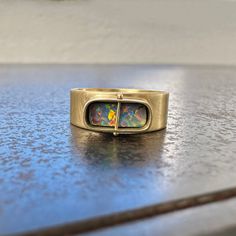 A soft-edged rectangular boulder opal with a kaleidoscope of colors is set in a luxe wide band of 18k gold. A one-of-a-kind ring with a multitude of flash every which way you look at it. This ring looks great on its own or stacked up with your favorites. 18k gold, boulder opal. Size 7. Ring Rectangle, Silver Smithing, Boulder Opal Ring, Opal Band, Wide Band Rings, Opal Ring, Boulder Opal, Wide Bands, Opal Rings