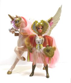 a toy figurine is dressed as a fairy riding a pink horse with wings