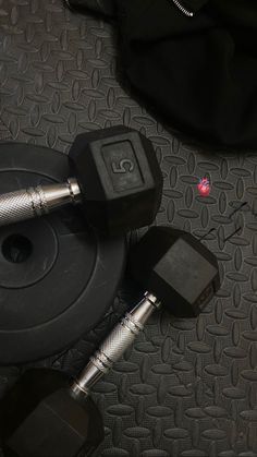 two black dumbbells and one silver dumbbell