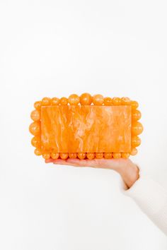 Our Daphne clutch is an exquisite fashion statement. Hand crafted and beautifully made, this piece is truly a work of art! This clutch is fashioned with beaded accents around the edges of the purse. Engraved with the LINNY CO brand on reverse side of the purse. Details and materials are outlined below. Material: Acrylic Color: Marbled Orange Unlined Fits an iPhone 14, lip gloss, keys and card case Snap Closure Size of actual bag exclusive of the beaded accents: 18x10x4.5mm Handle with care, coul Chic Beaded Pouch Clutch, Chic Beaded Clutch As A Gift, Elegant Orange Clutch For Party, Orange Rectangular Clutch For Formal Occasions, Chic Beaded Rectangular Clutch, Luxury Beaded Rectangular Clutch, Orange Rectangular Formal Clutch, Chic Rectangular Beaded Clutch, Elegant Orange Clutch As A Gift