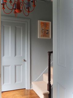 an open door with a chandelier hanging from it's side and stairs leading up to the second floor