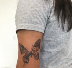 a woman with a butterfly tattoo on her left arm and right arm behind her back