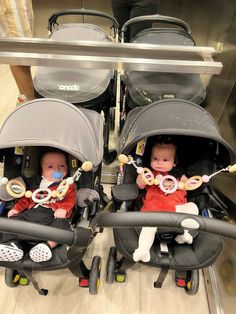 two babies sitting in strollers with pacifiers on their heads and looking at the camera