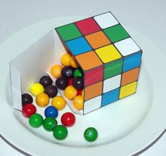 there is a cake made to look like a rubik cube and some candy balls