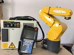 an industrial robot sitting on top of a table next to a calculator and machine