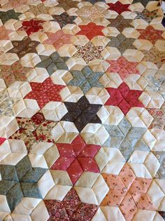 an old quilt that has been made into a bed spread with many different colors and shapes