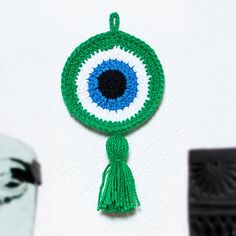 a crocheted eyeball ornament hanging on a wall