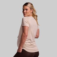 Made to be the most versatile shirt in your arsenal. We took your classic, everyday shirt and added extra stretch and a quick-drying material for all-day comfort. Finished with ruched sides that provide plenty of room for your growing belly, this is the shirt you'll reach for during every stage of your pregnancy. Beige Stretch Athleisure Top, Beige Stretch Tops For The Gym, Beige Stretch Top For The Gym, Beige Stretch Top For Gym, Beige Stretch Gym Top, Sporty Beige Workout Tops, Cream Crew Neck Athleisure Top, Athleisure Cream Crew Neck Top, Casual Beige Workout Tops