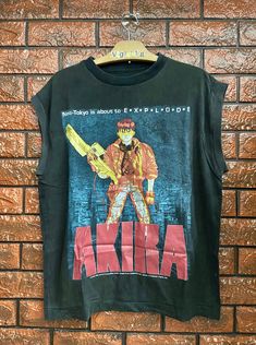 Distressed Akira Japanese Cyber Punk Anime 1988 Movie Poster Sleeveless T Shirt / Japanese Cyberpunk Anime / Pop Culture T Shirt Size L Condition : Heavy Used Size on tag : L (Resized) Colour : Black Brand : Unknown Measurement : Armpit to armpit - 22" Length - 27" Material : Cotton Made In: Unknown THE SHIPPING (Your Choice Please read) 1. The shipping cost is USD 20 via Malaysian Registered Postage With Tracking Number. It will take 2-4 weeks or more for delivery, depends on your custom checki Punk Sleeveless Cosplay Tops, Punk Style Sleeveless Tops For Cosplay, Punk Sleeveless Tops For Cosplay, Grunge Graphic Print Vest For Streetwear, Edgy Tank Vest With Graphic Print, Alternative Sleeveless Cosplay Tops, Punk Tank Top For Cosplay, Punk Style Sleeveless Tank Top For Cosplay, Japanese Cyberpunk