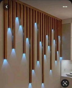 a bathroom with wooden slats and blue lights on the wall next to the sink