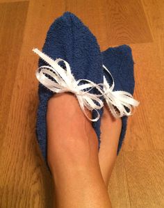 a person's foot with a blue towel wrapped around them on a wooden floor