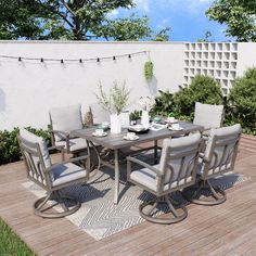 an outdoor dining table and chairs on a deck