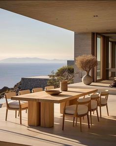 an outdoor dining area with table and chairs overlooking the ocean