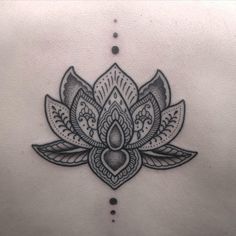 the back of a woman's stomach with a lotus tattoo on it