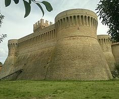 an old castle like structure with grass and trees around it