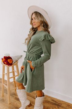 - Step out in charm with this darling mini dress! Featuring ruffled shoulders and a cinched waistline, it's perfect for effortless everyday elegance. - Unlined, ultra-soft material with a brown, blue, and green hued striped pattern - A crew cut neckline - Long sleeves with ruffled shoulder details - A functional drawstring to cinch the waist - Hidden side pockets - A relaxed yet flattering silhouette that ends in a straight mini dress length hemline September Fashion, Concert Fashion, Sweater Jumpsuit, Leather Cowboy Boots, Essential Dress, Striped Mini Dress, Crew Cuts, Teacher Style, Lifestyle Shop