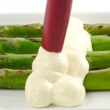 asparagus with mayonnaise on white plate next to red toothpick