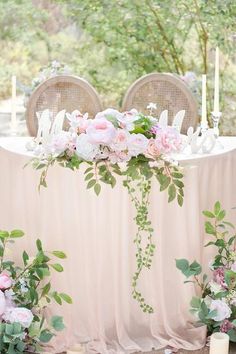 the table is decorated with pink flowers and greenery