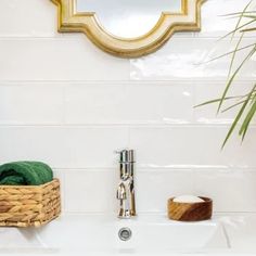 a bathroom sink with a mirror above it and towels in a basket next to it