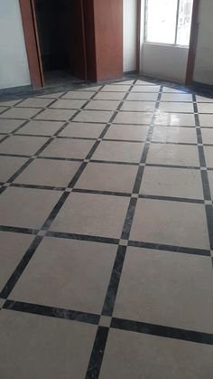 an empty room with black and white tiles on the floor