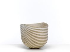 a white striped bowl sitting on top of a table