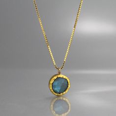 An organic yet delicate round pendant necklace featuring a gorgeous rose cut natural labradorite gemstone. The pendant is 22K solid gold welded on silver. Unique and elegant, this labradorite pendant set is like an eye to our inner spirit. The chain is 14K gold. This necklace will add a touch of elegance to your outfit, whether worn day or night. Measurements: Labradorite: 10mm Necklace length: 41.5 cm Materials: Stone: labradorite Metal: 22K solid gold, welded on sterling silver, 14k gold, silv Elegant Gold Necklace With Labradorite, Elegant Gold Labradorite Necklace, Elegant Labradorite Necklaces With Birthstone, Necklace Gold Pendant, Gold Necklace Wedding, Statement Necklace Gold, Round Pendant Necklace, Labradorite Necklace, Necklace Wedding