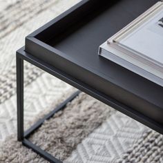 a coffee table with a book on it and a rug in front of the table