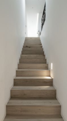 a set of wooden stairs leading up to a white wall