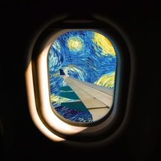 looking out an airplane window at the starry night painting on the wall behind it