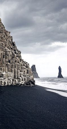 the black sand beach has stacks of rocks on it