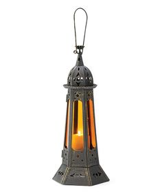 an old fashioned metal lantern with a candle in the middle and a light on top