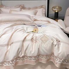 a bed with white comforter and pillows on top of it, next to a chair