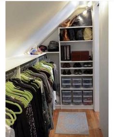 an attic closet with lots of clothes and shoes