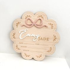 a wooden sign that says enjoy jade with a pink bow on it's head