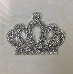 a silver tiara on a white marble surface