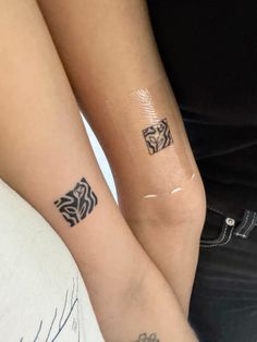 two people with matching tattoos on their arms