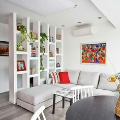 a living room filled with white furniture and lots of bookshelves on the wall