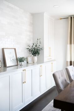 a dining room table with white chairs in front of it