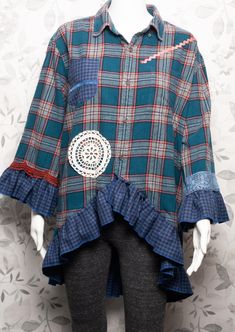 a mannequin wearing a blue plaid shirt with ruffles and a white lace applique