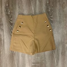 These Shorts Feature A 3 Gold Button Detail On Each Side, Faux Pockets, Back Welt Pocket, Side Seam Zipper, And High Waist. Measurements Waist - 12” Rise - 13” Length- 4” Color - Tan/Khaki Size - Xsmall Condition - Nwot High-waisted Solid Shorts With Buttons, Solid Color High-waisted Shorts With Buttons, Solid High-waisted Buttoned Shorts, Solid Color Buttoned High-waisted Shorts, Chic Brown Button-up Bottoms, Trendy Solid Shorts With Button Closure, Trendy Solid Color Shorts With Button Closure, Chic High-waisted Shorts With Button Closure, Khaki Bottoms With Buttons