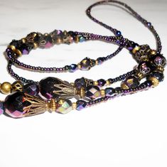 "Iridescent Purple Beaded Eyeglass Chain. Variety of faceted Czech glass beads with an AB finish, this gives the beads a rainbow effect. The lanyard is accented with antiqued brass filigree bead caps create a vintage look. I completed the lanyard with Czech glass seed beads with eyeglass connectors. Show off your unique sense of style when you wear this wonderful eyeglass chain. FEATURES > Total length 28\", may be adjusted upon request > Your choice of eyeglass connectors, skinny arm or wide arm. > To ensure long lasting wear I use professional quality beading wire (49 strand). The beading wire is very strong and flexible, providing a soft drape and it lays softly on the neck for maximum. Wire guardians are incorporated to protect wire from wear. The wire is double crimped for a secure ho Adjustable Faceted Beaded Necklaces For Parties, Faceted Adjustable Beaded Necklaces For Party, Adjustable Faceted Beaded Necklace For Party, Adjustable Iridescent Crystal Necklaces For Jewelry Making, Iridescent Necklaces With Faceted Beads For Gifts, Bohemian Glasses Chains With Colorful Adjustable Beads, Iridescent Necklace With Faceted Beads For Gift, Handmade Adjustable Bohemian Glasses Chains, Iridescent Crystal Necklace With Faceted Beads For Gift