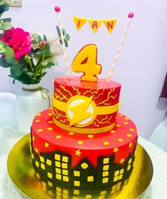 a red and yellow birthday cake with the number four on top is sitting on a gold plate