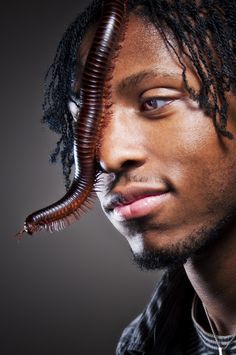 a close up of a person with a worm on his head and hair in the shape of a man's face