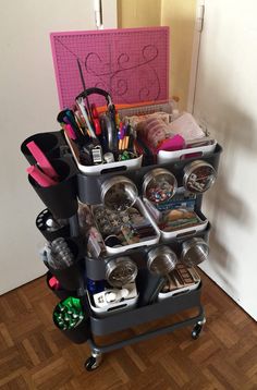 a cart filled with lots of different items on top of a hard wood floor next to a wall