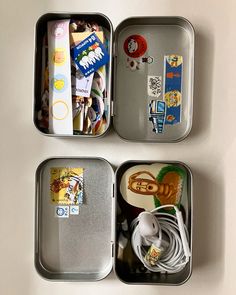 three tins with various items in them on a white table top and one has an earbud