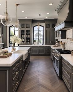 a large kitchen with gray cabinets and white counter tops, an island in the middle