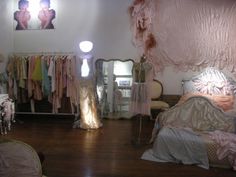 an image of a bedroom setting with clothes on racks